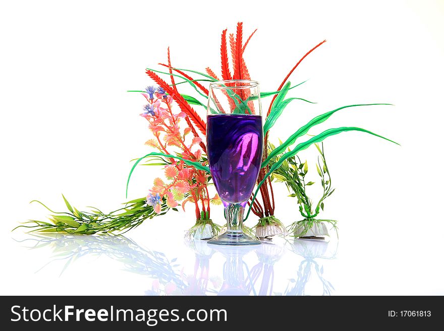 Blue mocktail glass with natural plants on white background.