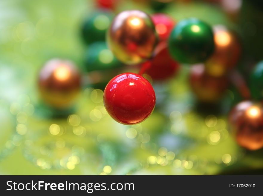 Closeup of colorful Christmas berry type decorations with focus on shiny red round one. Closeup of colorful Christmas berry type decorations with focus on shiny red round one.