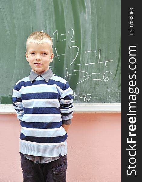 Happy young boy at first grade math classes solving problems and finding solutions