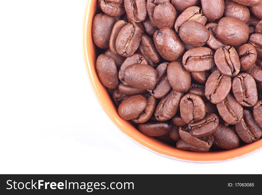 Looking down onto a mug full of coffee beans on a white background. Looking down onto a mug full of coffee beans on a white background