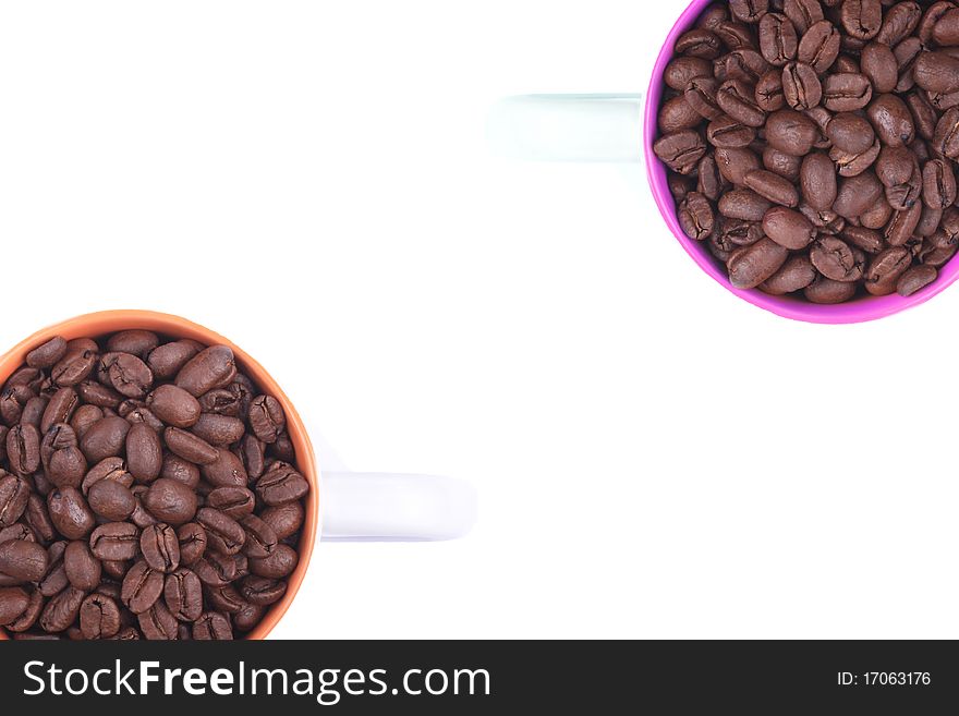 Two coffee cups full of coffee beans situated on a white background. Two coffee cups full of coffee beans situated on a white background.