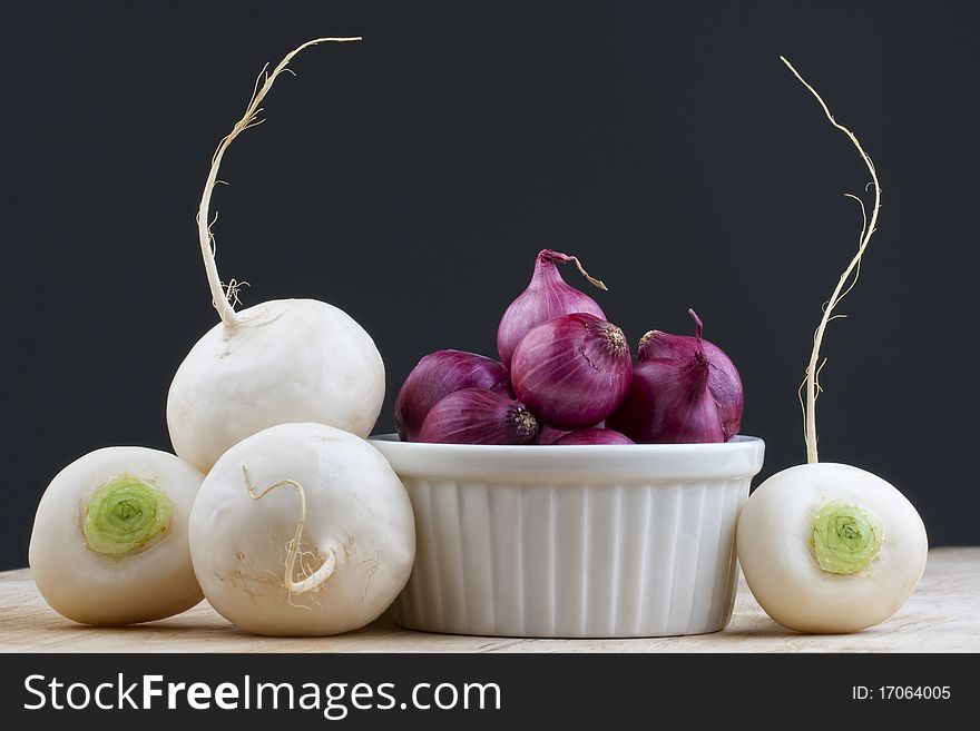 Four green tupnips with red pearl onions on the table