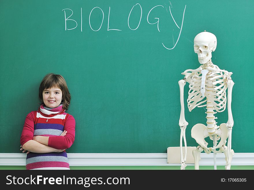 Happy children group in school classrom taking notes and learning biology and anatomy lessons with teacher. Happy children group in school classrom taking notes and learning biology and anatomy lessons with teacher