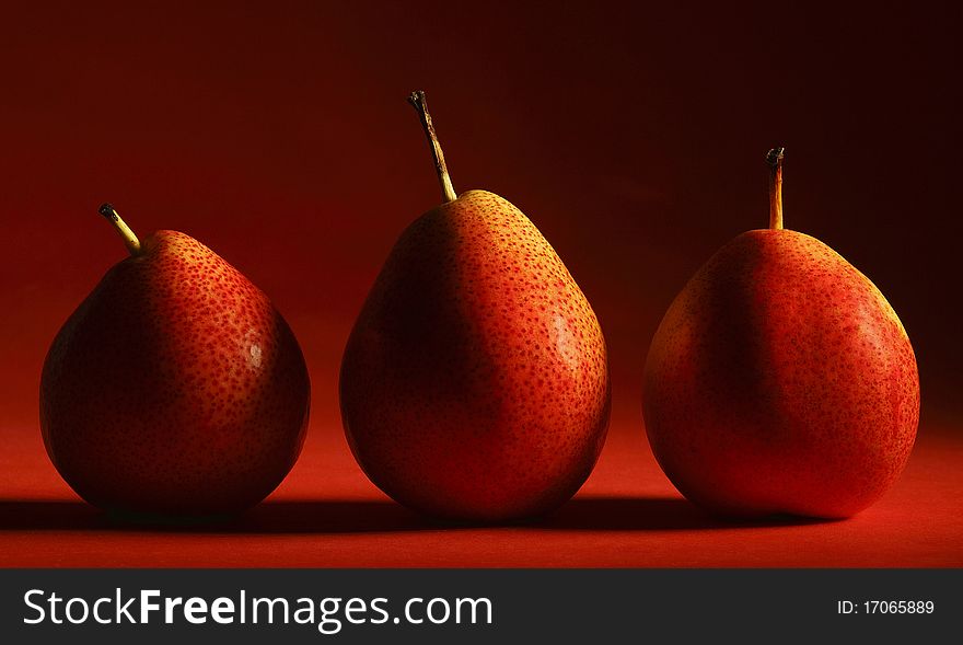 Three forelle pears on a gradated red background. Three forelle pears on a gradated red background