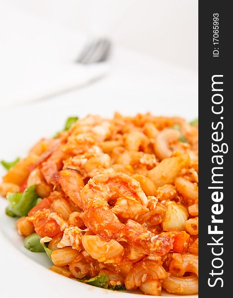 Colorful fried macaroni and fork in background. Colorful fried macaroni and fork in background