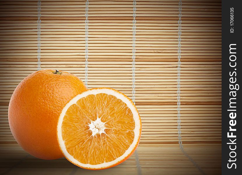 One and half oranges on bamboo mat