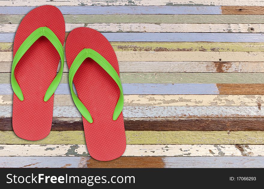 Red and green flip flop sandals on old wood