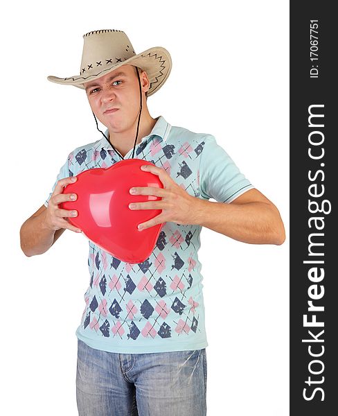 A young beautiful slender fellow in a cowboy hat gets on the hip an air ballon-heart. A young beautiful slender fellow in a cowboy hat gets on the hip an air ballon-heart