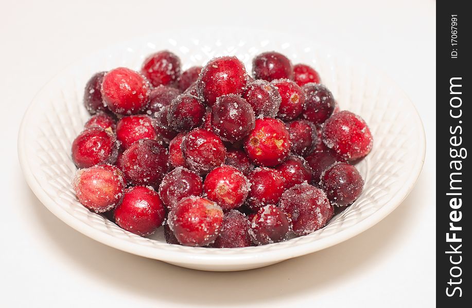 Sugared cranberries in a white china bowl, ready for the holidays. Sugared cranberries in a white china bowl, ready for the holidays