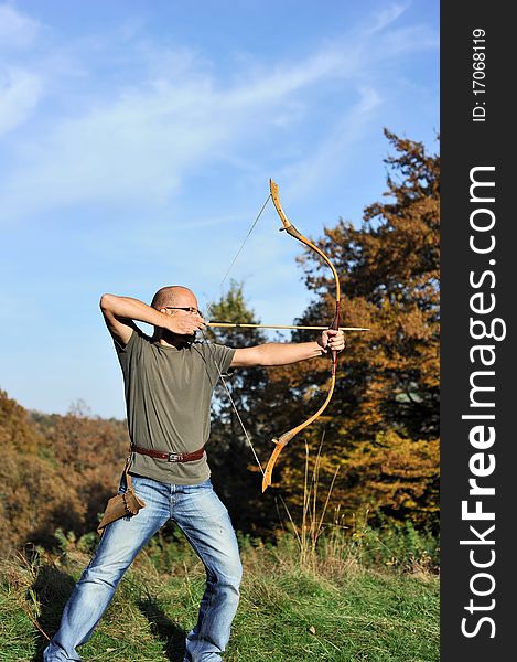 Man holding back an arrow and aiming to shoot. Man holding back an arrow and aiming to shoot.