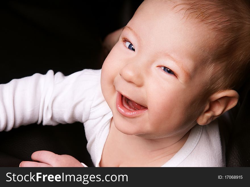 Portrait of joyful blue-eyed baby boy, studio shot