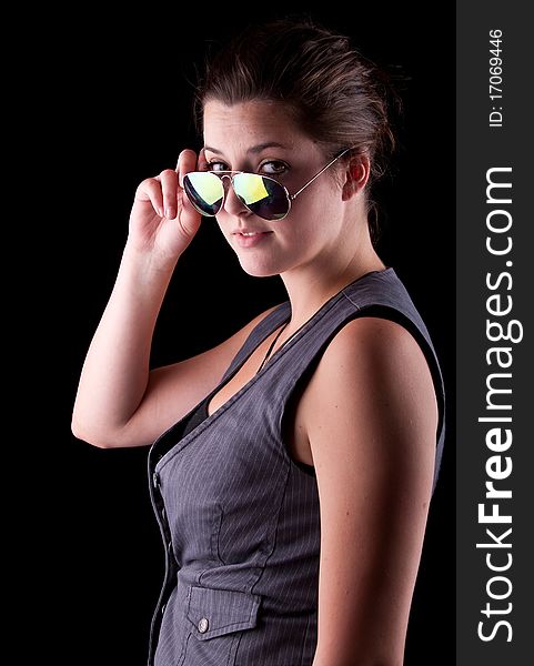 Young woman with cool sunglasses isolated over a pure black background. Young woman with cool sunglasses isolated over a pure black background.