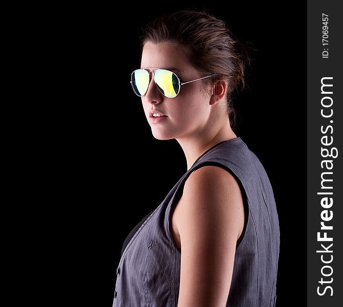 Young woman with cool sunglasses isolated over a pure black background. Young woman with cool sunglasses isolated over a pure black background.