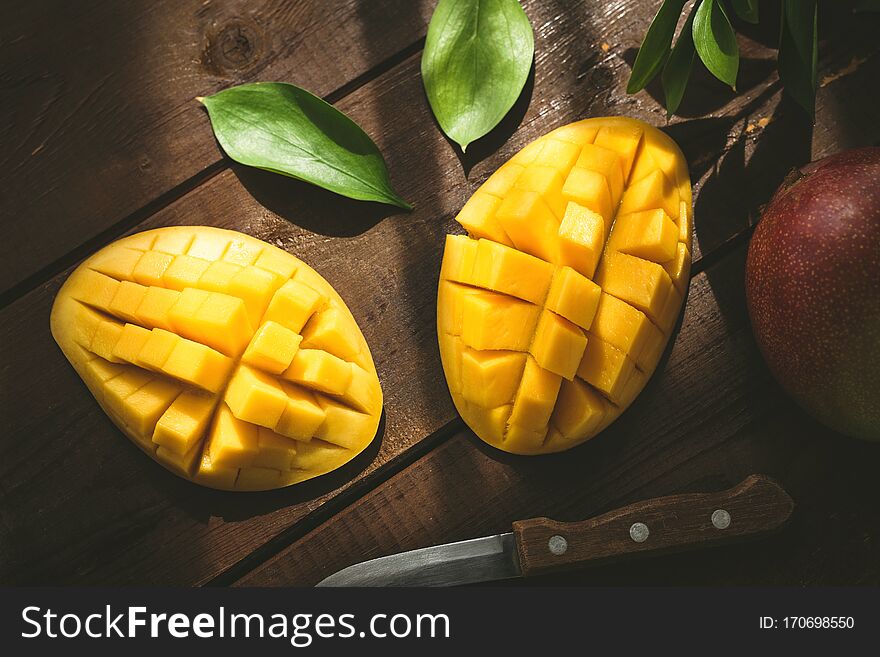 Mango halved and cubed. Tropical fruit on a wooden table. Top view