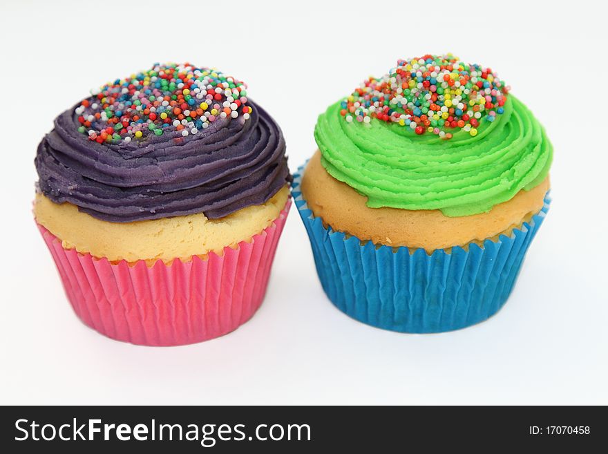 Colorful iced cupcakes with sprinkles.