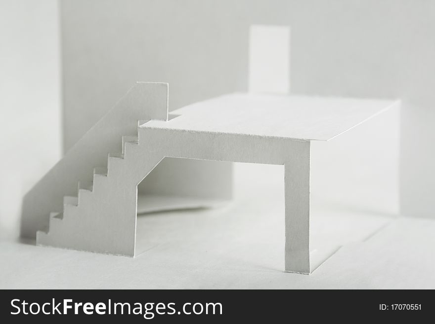 Paper cutout composition with white elements of building, terrace with stairs and door