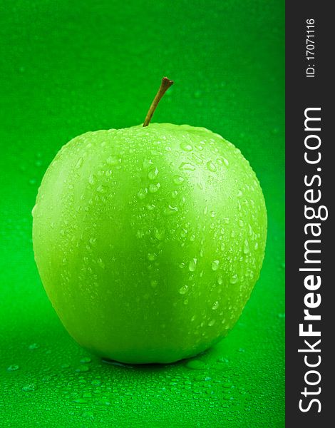 Fresh green apple with drops of water