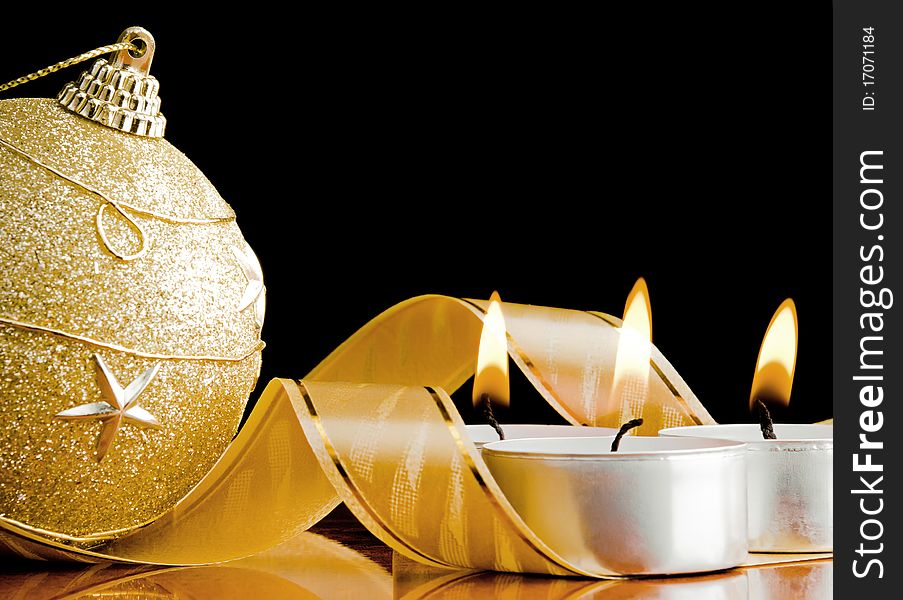 Close-up of the burning candles with new year's toy and ribbon. Close-up of the burning candles with new year's toy and ribbon