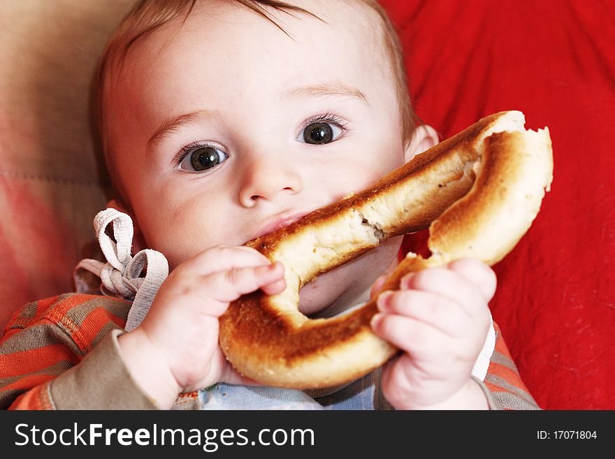 A small child is eating a bagel. A small child is eating a bagel