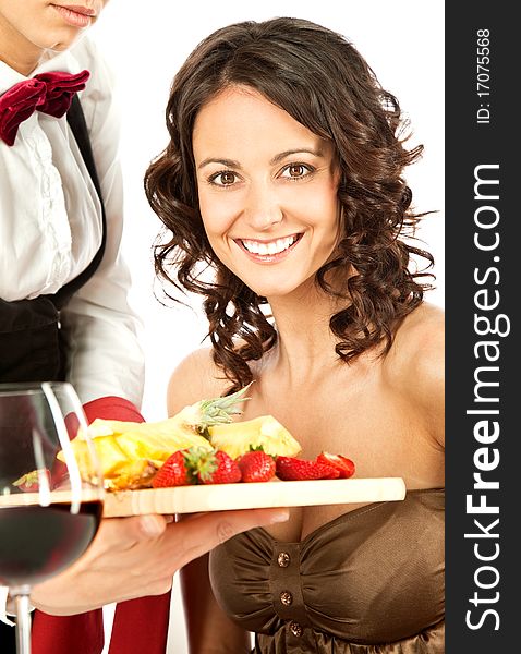 Beautiful smiling female being offered sliced fruits on by waitress. Beautiful smiling female being offered sliced fruits on by waitress