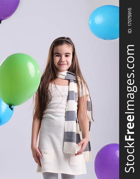 Little smiling girl with balloons in the studio