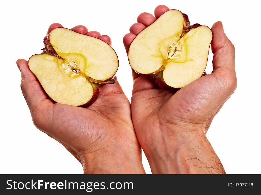 Red apple cut into two parts in male white hands isolated over white background. Red apple cut into two parts in male white hands isolated over white background.