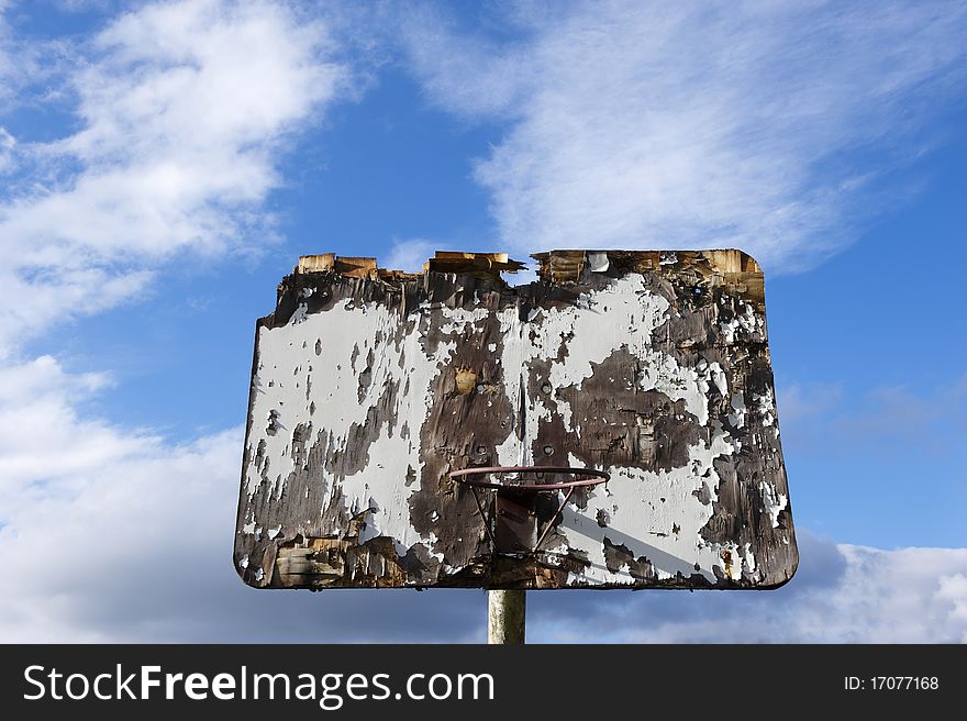 Old wooden basketball board in front of blue sky