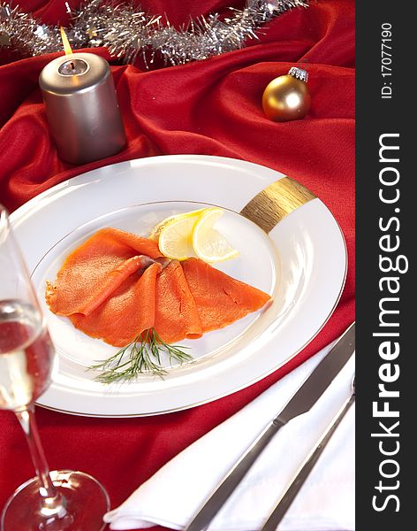 Smoked salmon with chives for Christmas, on a red-decorated table. Smoked salmon with chives for Christmas, on a red-decorated table