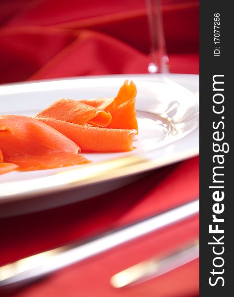 Smoked salmon with chives for Christmas, on a red-decorated table. Smoked salmon with chives for Christmas, on a red-decorated table