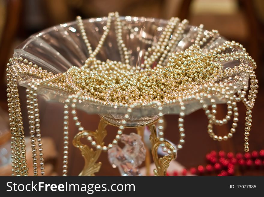 Many golden beads placed in glass vase. Many golden beads placed in glass vase