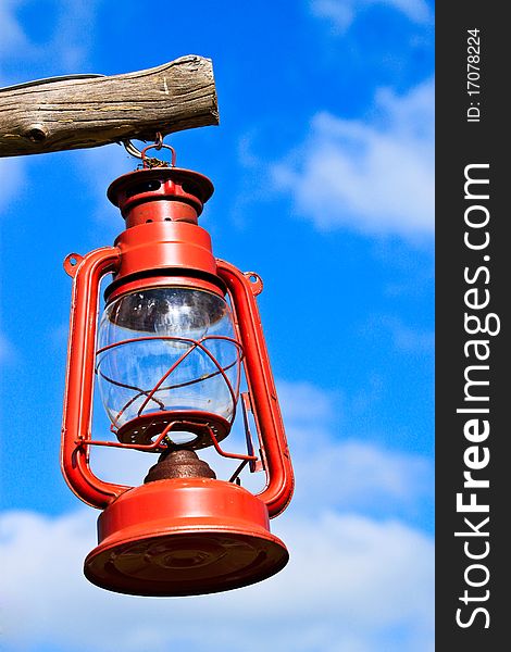 Old red lantern hanging by wood on blue sky. Old red lantern hanging by wood on blue sky