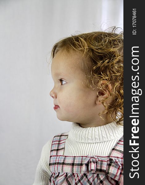 Profile of a young girl with curly hair looking determined. Profile of a young girl with curly hair looking determined.