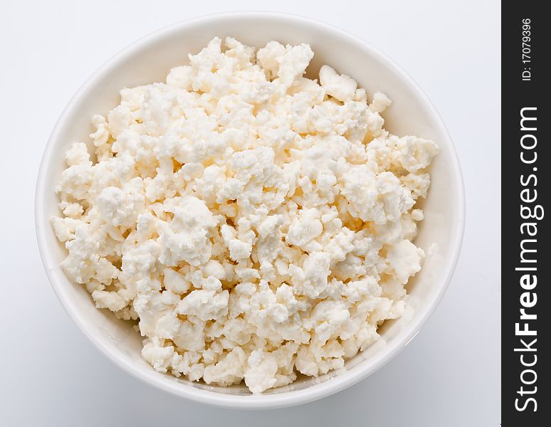 Bowl with fresh cottage cheese. Isolated on a white.