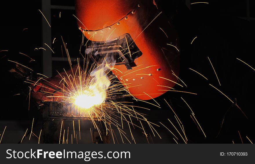 Worker with protective mask welding metal.