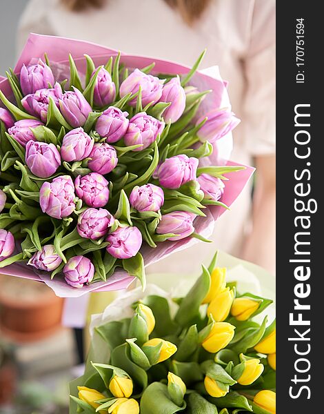 Two Beautiful bouquets of tulips in womans hands. the work of the florist at a flower shop. Delivery fresh cut flower. European floral shop