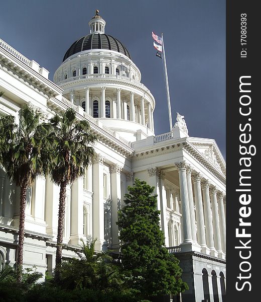 White building of Califonia State Capitol Museum and flags. White building of Califonia State Capitol Museum and flags