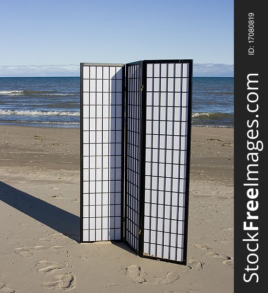 A black and white three-fold screen on the beach of a lake. A black and white three-fold screen on the beach of a lake.