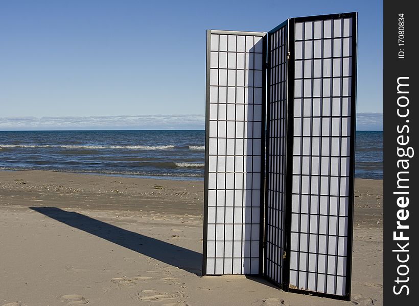 A black and white three-fold screen on the beach of a lake. A black and white three-fold screen on the beach of a lake.