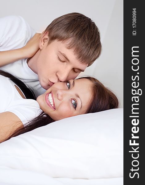 Happy young caucasian couple on the bed at home. Happy young caucasian couple on the bed at home