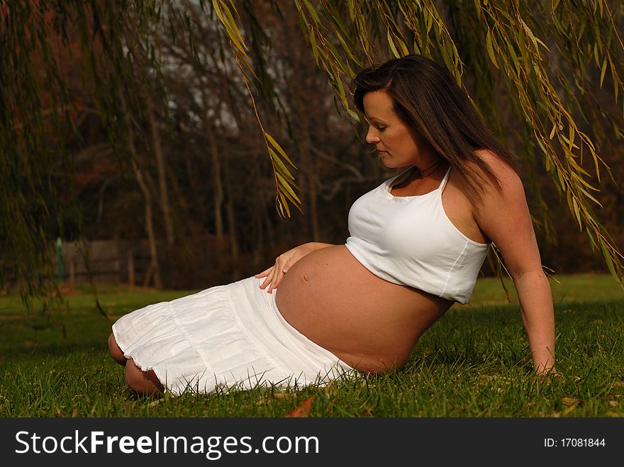 Beautiful young woman outdoors in seventh month of pregnancy. Beautiful young woman outdoors in seventh month of pregnancy.