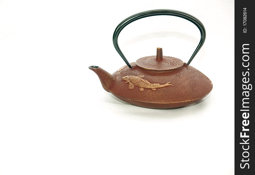 A japanese cast iron teapot is the subject. also included is a warming stand, cast iron teacups and metal teacup holders in the shape of a leaf that has been chewed on by insects. A japanese cast iron teapot is the subject. also included is a warming stand, cast iron teacups and metal teacup holders in the shape of a leaf that has been chewed on by insects.