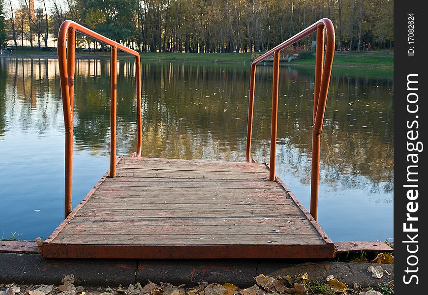 Small bridge on the autumn lake. Small bridge on the autumn lake