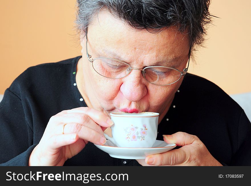 Portrait of a senior woman drinking tea (coffee)