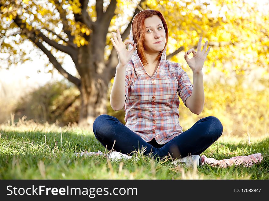 Portrait of red-haired girl in the autumn park. Outdoor shot.