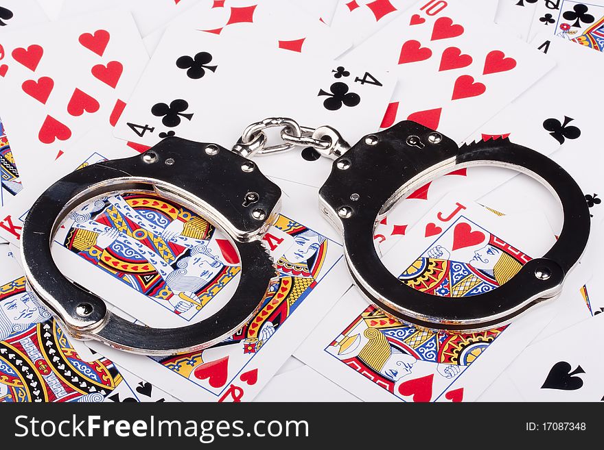 Handcuffs with things gaming - playing cards on a white background.
