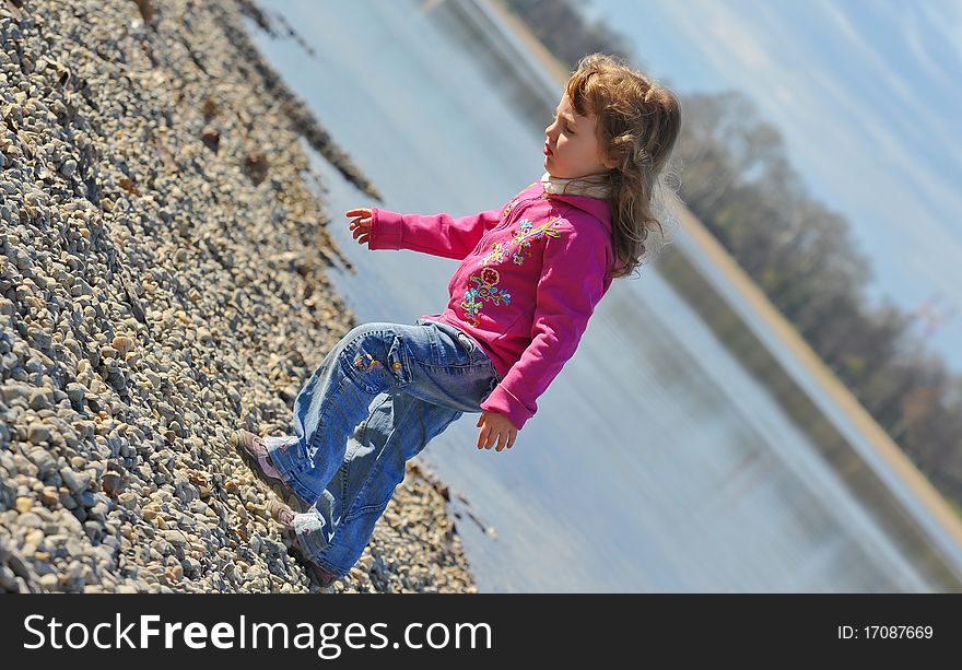 Little girl playing at the beach in winter