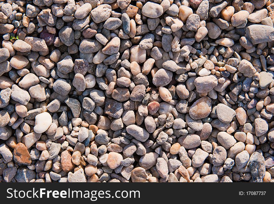 A pattern of pebbles lying on the beach near a lake in autumn. A pattern of pebbles lying on the beach near a lake in autumn