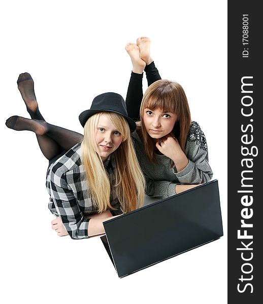 Two girls lies with computer on white background