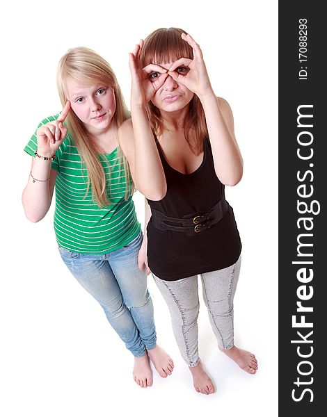 Two girls stand and make faces on white background