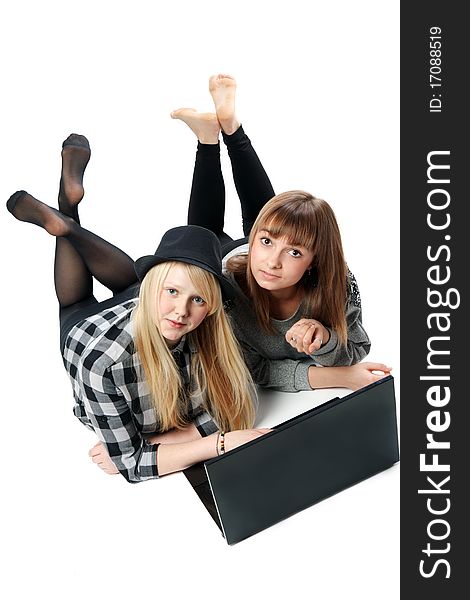 Two girls lies with computer on white background